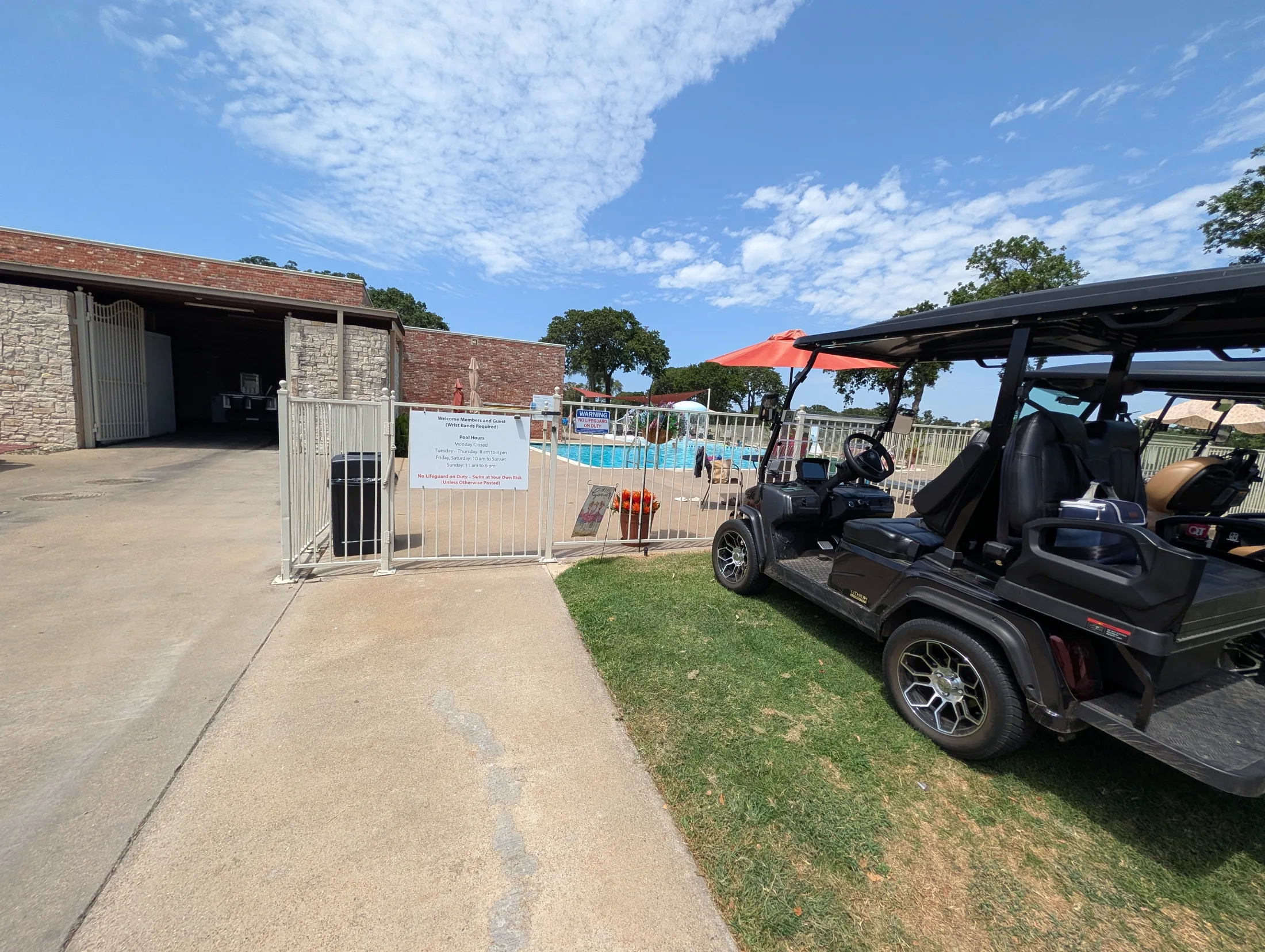 Golf cart parked beside the pool entrance at Cedar Creek Country Club